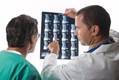 The doctor looks spinal pictures